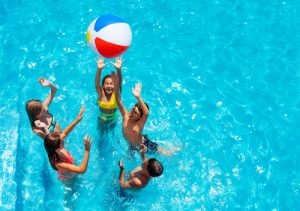 Group,of,kids,in,swimming,pool,play,with,inflatable,ball